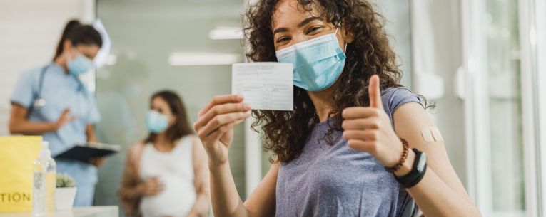 Allianz - woman holding COVID-19 vaccination card