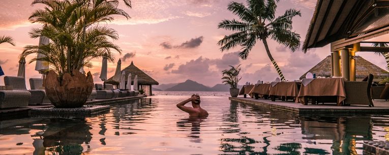 Allianz - man swimming at luxurious resort